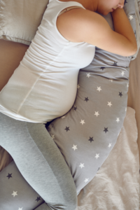 Donna incinta dorme sul fianco con cuscino