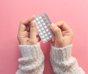 Mani di donna tengono in mano pillola anticoncezionale
